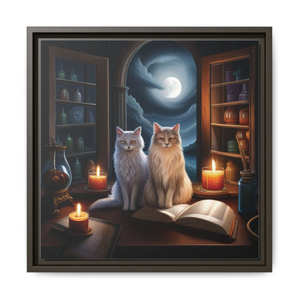 Framed canvas of two cats sitting by candlelight with an open spellbook under a moonlit window