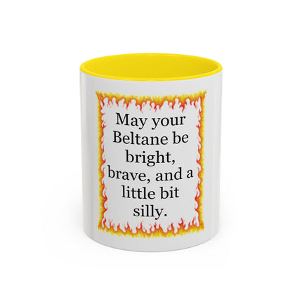 White ceramic mug with a colored interior featuring a hand‑drawn flame border and the Beltane blessing “May your Beltane be bright, brave, and a little bit silly.”